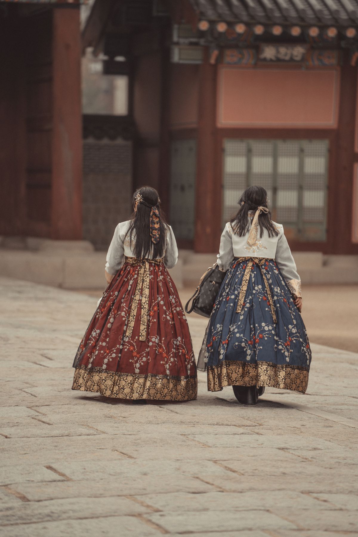 Visitors wearing rented hanbok traditional dress walking through Bukchon Hanok Village, Seoul