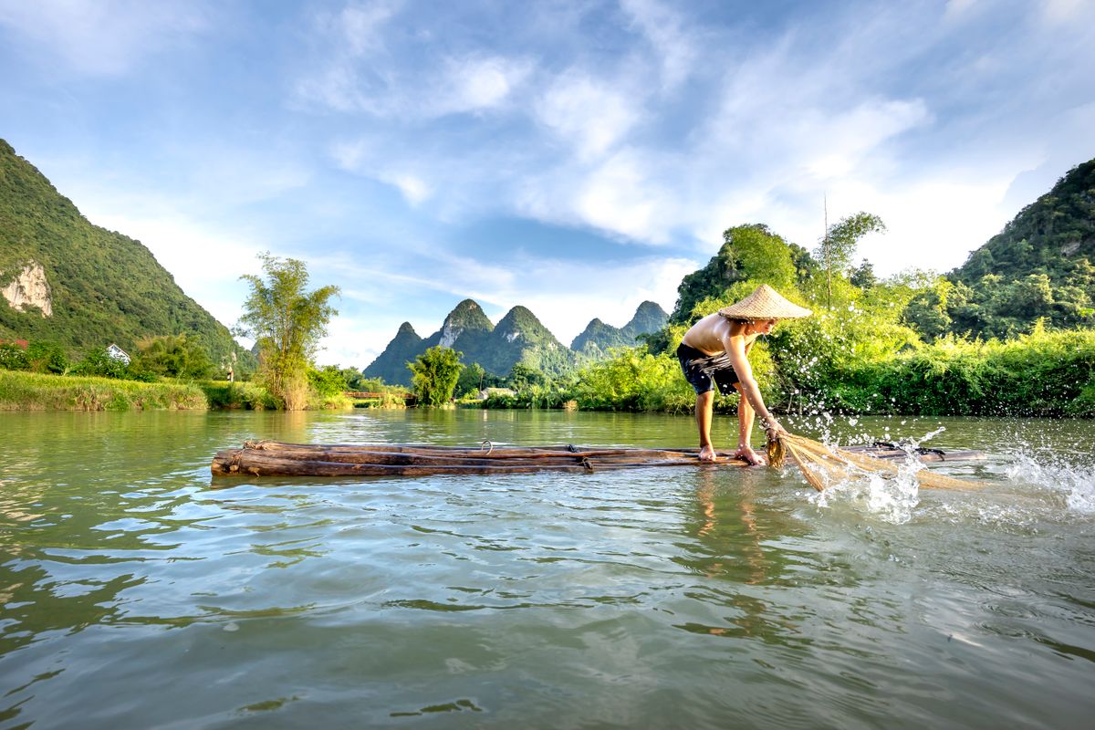 Bamboo raft with a boatman on the Li River between limestone hills