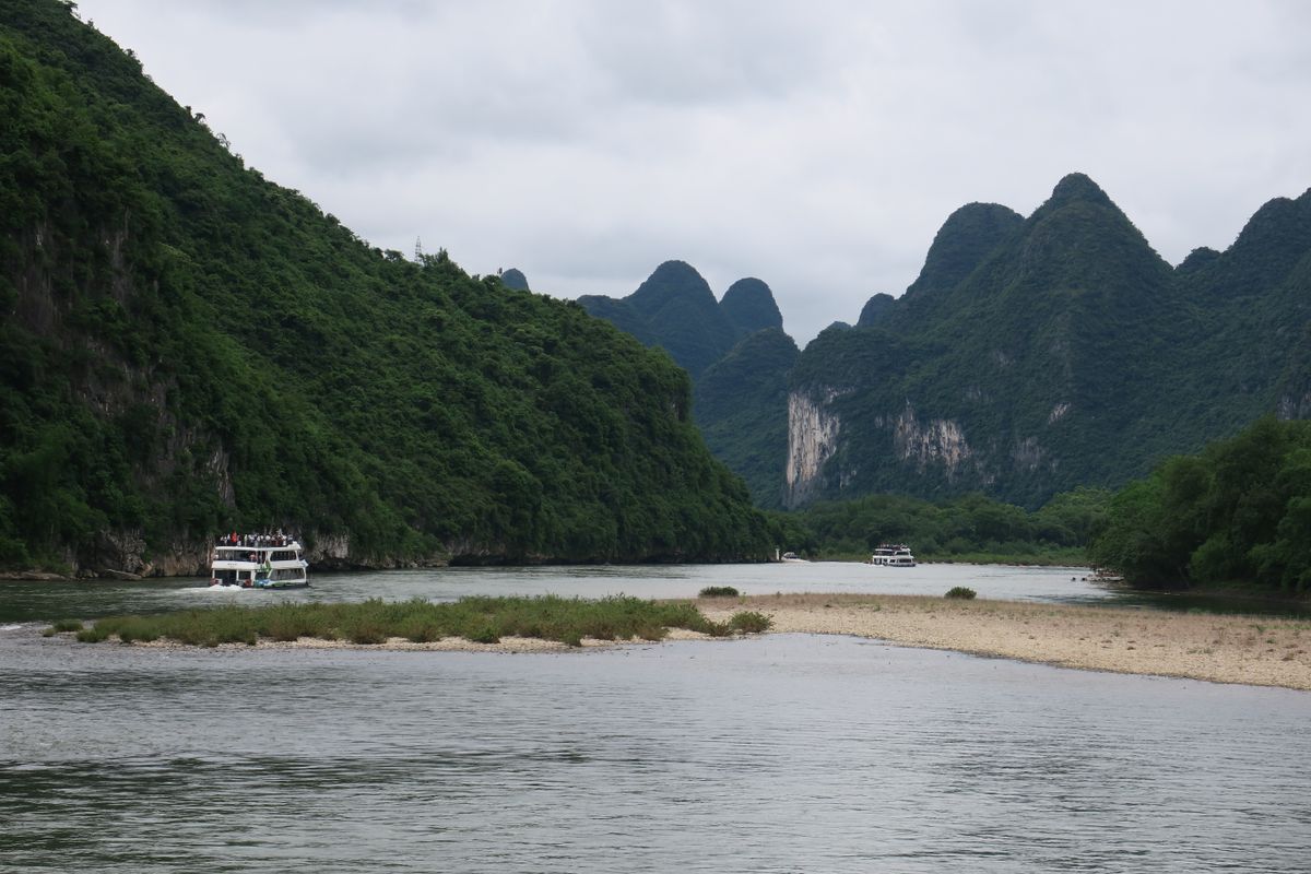 Cruise boats sailing the Li River surrounded by green karst mountains