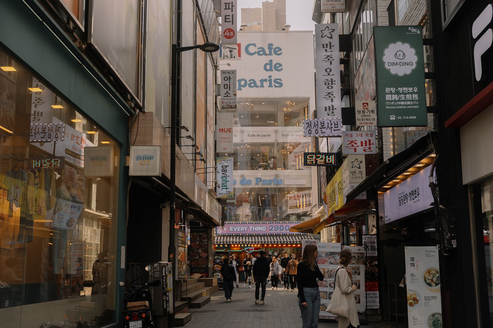 Bustling Myeongdong street in Seoul with rows of shops and pedestrian crowds