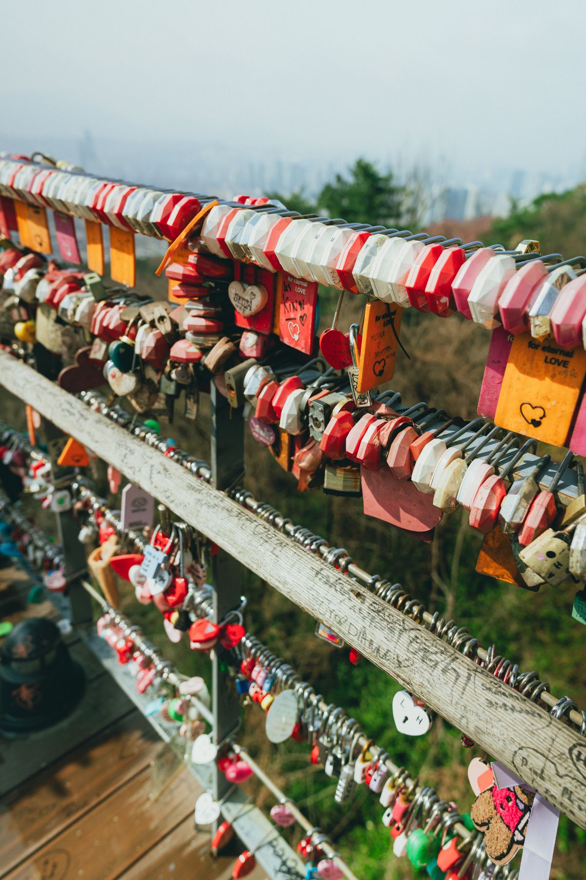 Colorful padlocks covering railings and a fence at N Seoul Tower