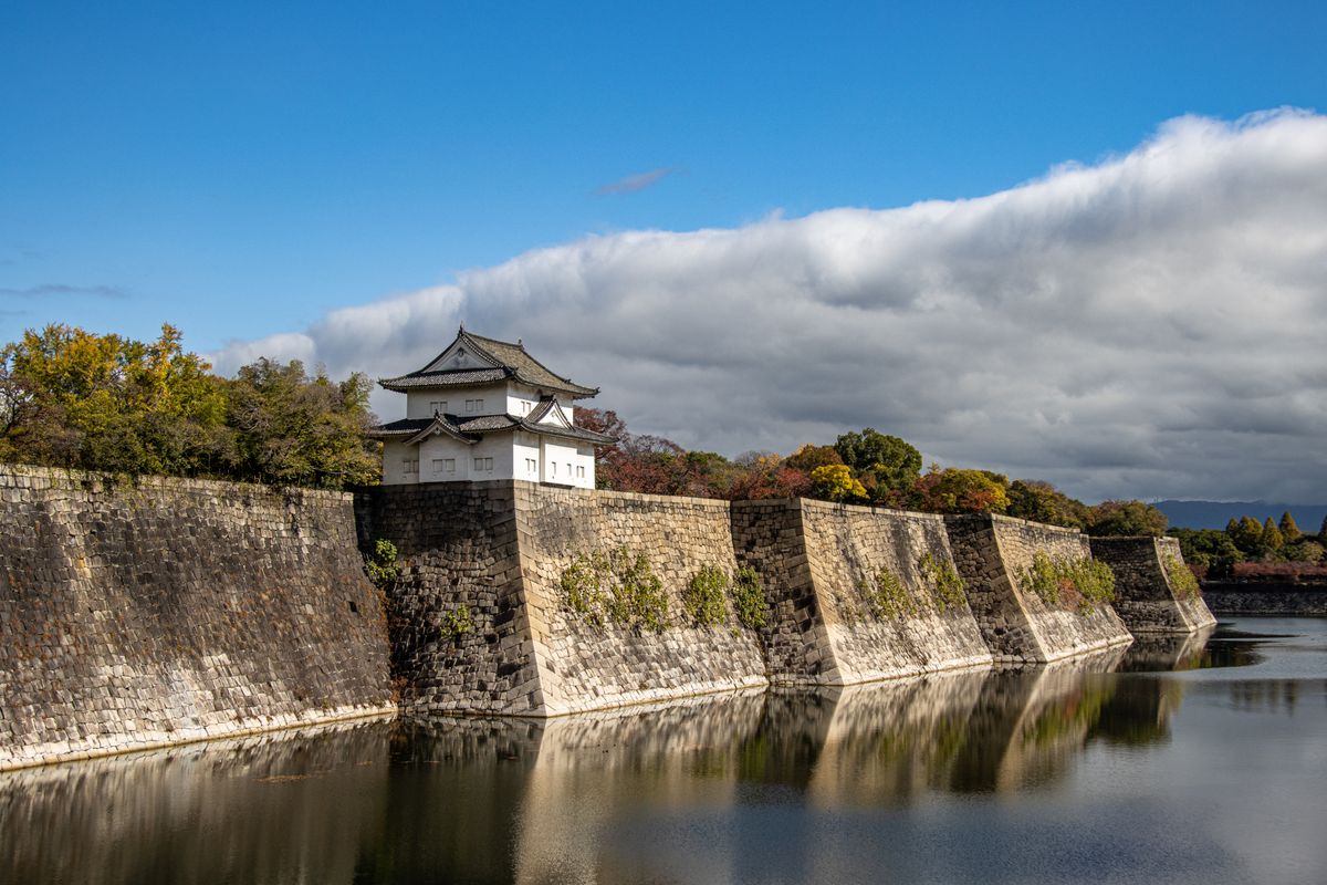 Osaka Castle stone walls reflecting in the surrounding moat water