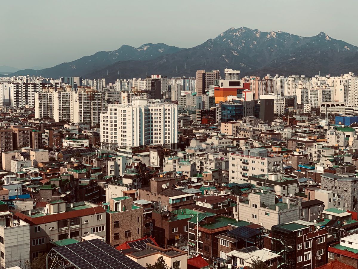 Aerial view of the Seoul skyline and surrounding mountains as seen from a high vantage point