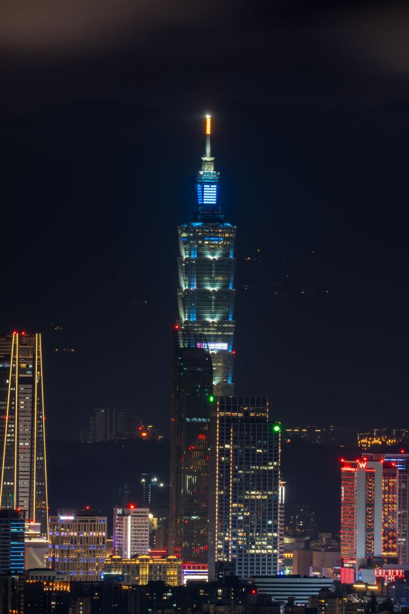 Taipei 101 illuminated at night over the Taipei skyline
