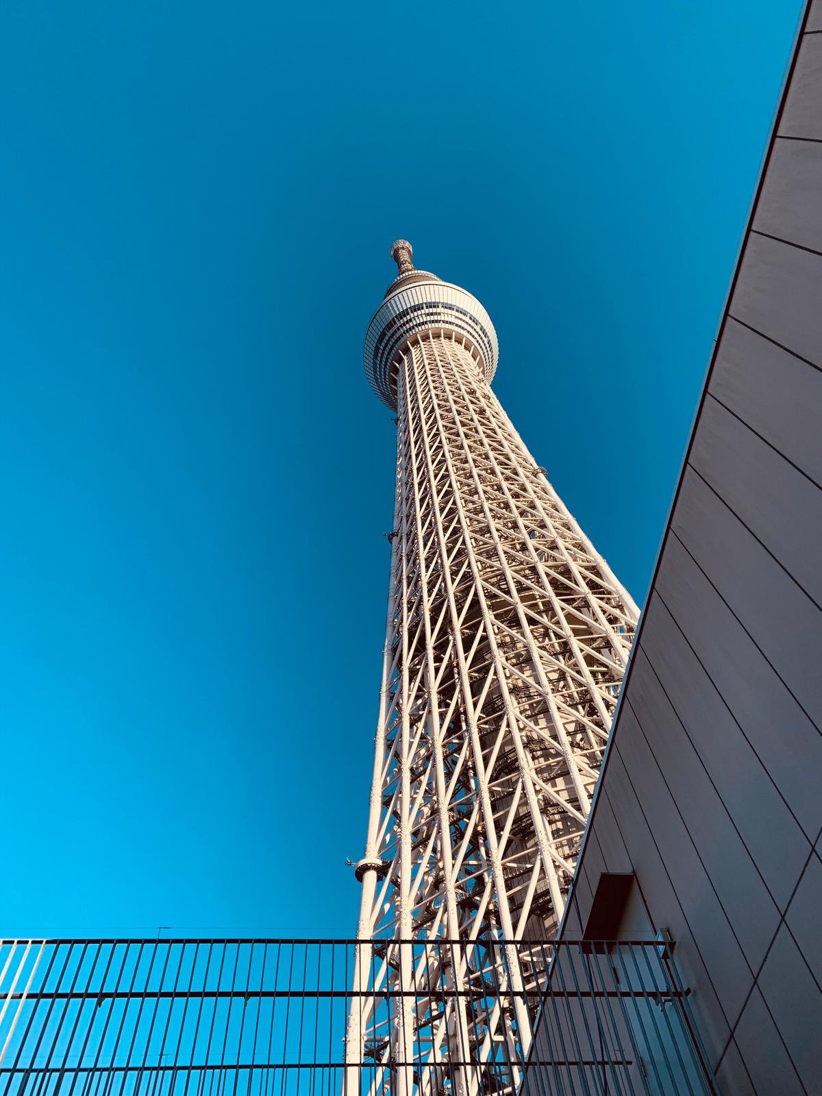 Tokyo Skytree tower viewed from below against a clear blue sky