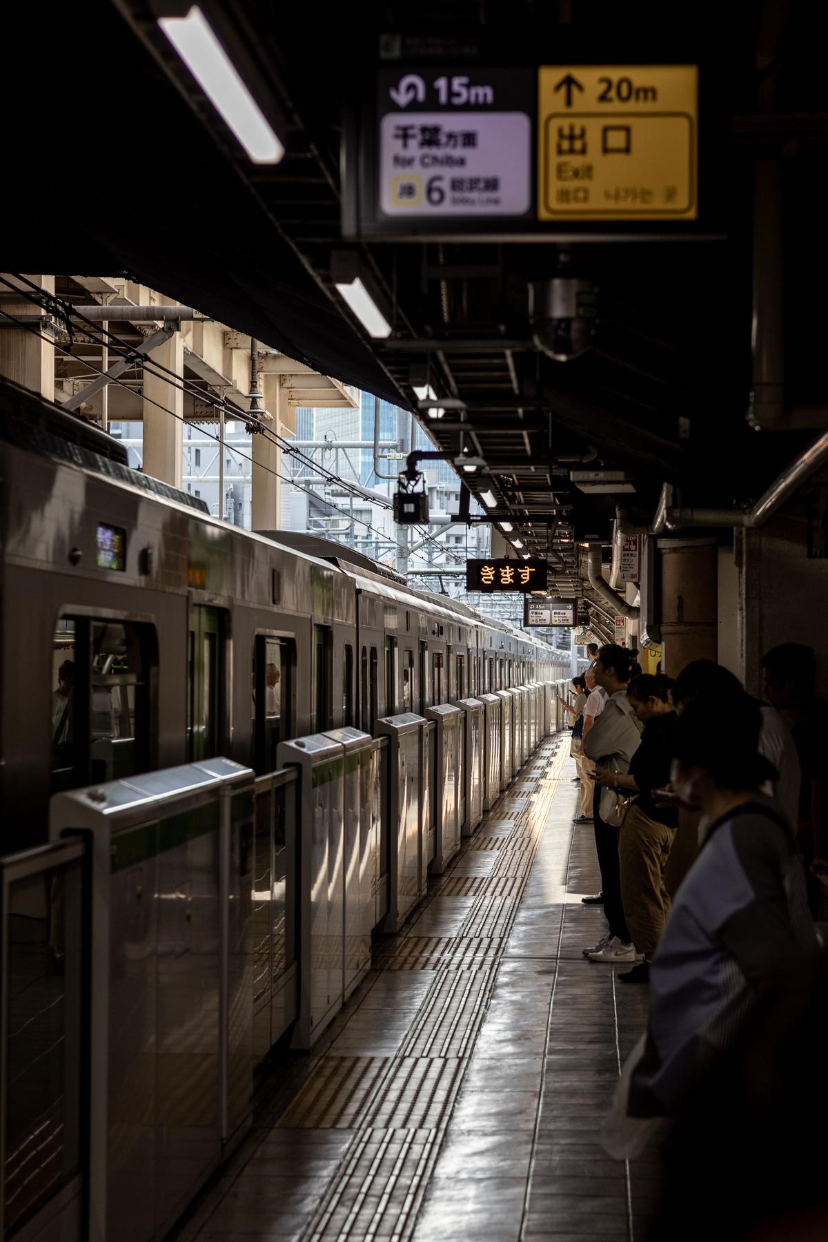 Passengers waiting on a Tokyo train station platform